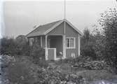 En stuga vid Kalmar södra koloniområde, fotograferad omkring 1930. Kalmar södra koloniförening grundades 1917 och har idag 105 kolonilotter. Området ligger strax söder om länssjukhuset i Kalmar med huvudingång från Stensbergsvägen.
