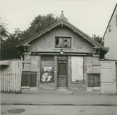 Mindre butiksbyggnad i kvarteret Beckasinen. Mot Södra vägen. Bilden tagen när fastigheten revs.