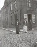 Kvinnor i hatt och kjol vid Kalmars nya skjortfabrik vid kvarter Hattmakaren.