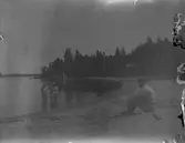 Här är en badscen, troligtvis från Harnäs. David Brundin sitter och tittar på sina tre döttrar som doppar fötterna.