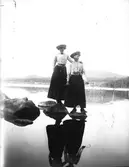 Elna Brundin och hennes kusin Anna Larsson från Hemlinggrind på utflykt, balanserande på hala stenar.