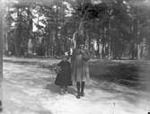 Eva och Ingrid Brundin har plockat vitsippor i Boulognerskogen, kanske 1921.