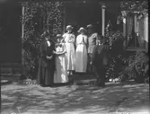 Obekant miljö. Personerna från vänster: Anna Larsdotter Olsson med sina tre döttrar Gertrud, Ingeborg och Naemi med uppvaktande kavaljer (möjligen Helmer Andersson, David Brundins kompanjon i firma Andersson och Brundin 1913). Mannen till höger okänd.