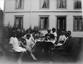 Okänd miljö, men paret till höger är rektorn i Huskvarna, Erik Rynning med fru. Erik var kusin till Elna Brundin. I mitten sitter David Brundin med dottern Karin bakom sig. På bänken till vänster sitter Ingrid, Sören och Eva Brundin, övriga okända. Kortet förmodligen från år 1924.