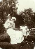 Elna Brundin med sin förstfödda Ingrid bakom sig och Karin i vagnen, 1915.