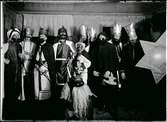 Julspelsgrupp/stjärngång i Köla i Värmland 1928. Figurerna är från höger: stjärnbäraren, en av de vise männen, timmermannen, två vise män, Judas, Svarte kungen, Herodes, dennes tjänare och i förgrunden julbocken.