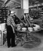 En man synar porslinet vid Gefle Porslinsfabrik.