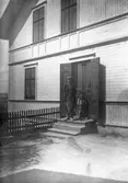 På trappan till huset. Tidsomfånget är 1900 - 1940