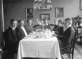 Sitter runt matsalsbordet. Tidsomfånget är 1900 - 1940