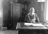Sigrid vid skrivbordet. Tidsomfånget är 1900 - 1940