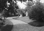I trädgården. Tidsomfånget är 1900 - 1940