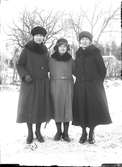 Tre kvinnor i vinterkläder.