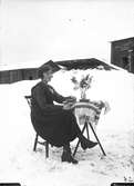 Kvinna vid bord, utomhus i snön.
