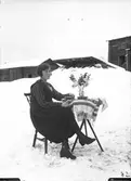 Kvinna vid bord, utomhus i snön.