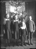 Fyra barn framför julgran.