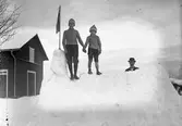 Ragnar Hillström, f. 1901 (tv) och Folke Hillström, f. 1906 (th) i snöfästningen, Per Larsson står bakom. Ladan till vänster i bild.