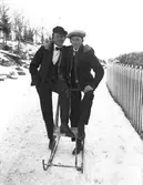 Två unga män på sparkkälke.