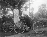 Två kvinnor med cyklar.