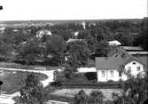 Vy över bostadsområde, Bergby. Längst fram till höger Bergby vita skola och bakom den gamla skolan. Den vita villan till vänster byggdes av Knut Persson och köptes av kommunen vid konkurs i början av 1930-talet och användes sedan som bostad åt bankkamrer Fasén och till kommunalhus.