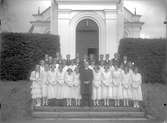 Gruppfoto av konfirmander med kyrkoherde Henrik Lindberg från början av 1900-talet.