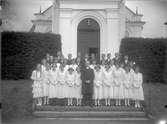 Gruppfoto av konfirmander med kyrkoherde Henrik Lindberg från början av 1900-talet.