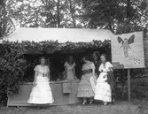 Utklädda kvinnor vid ett stånd med kärlekstema.