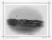 Gård i Utvalnäs. Kvinna med två pojkar utanför.