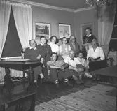 Bakre raden från vänster: 1. Gustav Eriksson. 2. Marta Eriksson. 3. Anna Eriksson. 4. Anna Hedlund. 5-6. Okänd. Sittande från vänster: 1. Hans Eriksson. 2. Erik Persson. 3. Greta Olsson. 4. Emma Persson