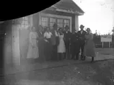 Gruppfoto, män och kvinnor utanför stationshuset i Fågelsjö.