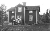 Från vänster muraren Anders Wilhelm Alm, Karin Östlund-Alm med sonen Sune på armen. Bakre raden Linnea, Karin, Nanny, Brita, Märta, Stina, mormor och August. Åsmundshyttan