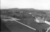 Vy mot Heden i Bollnäs köping, troligen från prästgårdens tak. Närmast till höger församlingshuset och Schenströms, där bortom Schenströms ladugård. Samrealskolan ännu ej byggd. Till vänster syns en bit av den nya kyrkogården.