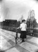 Ester Lindberg vid gamla bron i Lenninge. Lennebys ladugård i bakgrunden.