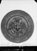 Medalj med text: C. Hyckert. H J Nettelbladt. Ernst Vegesack.