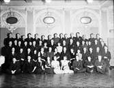 Hakonbolagets fest på Grand.En samling kvinnor och män sitter och står inför en gruppbild på personalen.