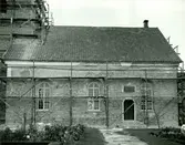 Böda kyrka under restaureringen 1942. Långhusets södra yttervägg, med nedknackad puts, där man ser det medeltida murverket under.