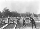 Arbete på Idrottsplatsen. Den gamla idrottsplatsen från 1903 på Mattons vretarna, även kallad Strömdalens idrottsplats. Gävle stad upplät idrottsplatsen 1914 till Gefle Idrottsförening, IFK Gävle och Gefle Sport- och Gymnastikförening, då anlades löparbanor t.v Elofsson
Reproduktion av Carl Larsson
