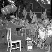 Rörbergs barnkoloni. 10 augusti 1956. Bilden publicerades i Arbetarbladet på sidan Släkt & vänner 27 januari 2014. Camilla Magnusson svarar den 29 januari 2014 att det är hennes mamma, Sylvia Magnussons morbror Emilio Palma (1891-1961) som fyller ballongerna med helium vid Frälsningsarméns barnkoloni i Rörberg 1956.

