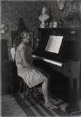 Flicka vid piano.
