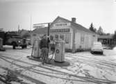 Vid bensinstationen Koppartrans står en man vid pumparna.