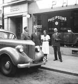 Fyra personer utanför Philipsons Bil AB i Gävle. Bilen en 1938 DeSoto.
