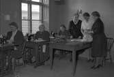 Hjälpbyrån i Heliga Trefaldighets församling. Kvinnor som syr kläder. Januari 1950.
