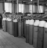 Gävle Manufaktur AB, Strömsbro. Juni 1946. På fabriken jobbade många ogifta textilarbeterskor, Några av dem bodde i den så kallade flickbyggningen. Gefle Manufaktur AB ägde Svanens väv i Strömsbro, som länge var den största fabriken i landet för tillverkning av bomullstyger och garn. Fabriken startade år 1849. Men det blev andra tider med krig, konflikter och sämre konjunkturer, då gick det sämre även för Svanens väv som tvingades lägga ned år 1960.
