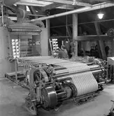 Gävle Manufaktur AB, Strömsbro. Juni 1946. På fabriken jobbade många ogifta textilarbeterskor, Några av dem bodde i den så kallade flickbyggningen. Gefle Manufaktur AB ägde Svanens väv i Strömsbro, som länge var den största fabriken i landet för tillverkning av bomullstyger och garn. Fabriken startade år 1849. Men det blev andra tider med krig, konflikter och sämre konjunkturer, då gick det sämre även för Svanens väv som tvingades lägga ned år 1960.
