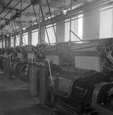 Gävle Manufaktur Aktiebolag Strömsbro. Juni 1946.
På fabriken jobbade många ogifta textilarbeterskor, några  bodde i den så kallade flickbyggningen. Det var Gefle Manufaktur AB som ägde Svanens väv i Strömsbro, som länge var den största fabriken i landet för tillverkning av bomullstyger och garn. Fabriken startade år 1849 och produktionen gick strålande. Men det blev andra tider med krig, konflikter och sämre konjunkturer och då gick det sämre även för Svanens väv som tvingades lägga ned 1960. 300 anställda förlorade då sina jobb. Efter nedläggningen stod Strömsbrofabriken tom i många år. Den gamla fabriksbyggnaden blev sedemera Industri-huset Vävaren, som sedan 1970-talet använts som industrihotell.
