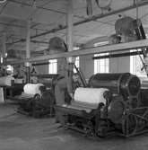 Gävle Manufaktur AB, Strömsbro. Juni 1946. På fabriken jobbade många ogifta textilarbeterskor, Några av dem bodde i den så kallade flickbyggningen. Gefle Manufaktur AB ägde Svanens väv i Strömsbro, som länge var den största fabriken i landet för tillverkning av bomullstyger och garn. Fabriken startade år 1849. Men det blev andra tider med krig, konflikter och sämre konjunkturer, då gick det sämre även för Svanens väv som tvingades lägga ned år 1960.
