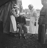 Militärbefäl och Lottakåren. Hjälper skadade