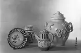 Husgeråd och prydnadsföremål. Kanna, urna, tallrik och vas.  Bobergs Fajansfabrik AB.