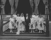 Brudparet Bergstrands med brudtärnor på trappan till Strömdalens värdshus

