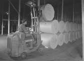 Rullarna körs med truckar till pappersmagasinet, Korsnäsverken. Den 2 november 1948. Korsnäs AB är ett av Sveriges ledande skogsindustriföretag som tillverkar kartong, säck- och kraftpapper, fluffmassa till hygienprodukter och sågade trävaror.