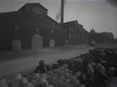 Fabriksbyggnader och upplag av tunnor på Barlastholmen.